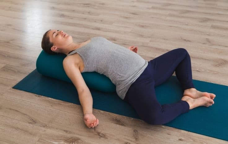 reclined bound angle pose with bolster